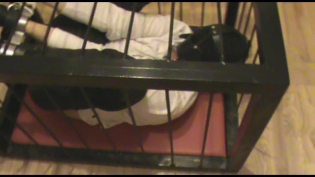 Rigidcuffed slave in a cage